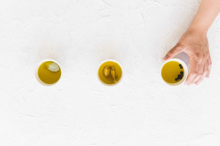 hand-holding-bowl-oil-white-textured-backdrop hand-holding-bowl-oil-white-textured-backdrop
